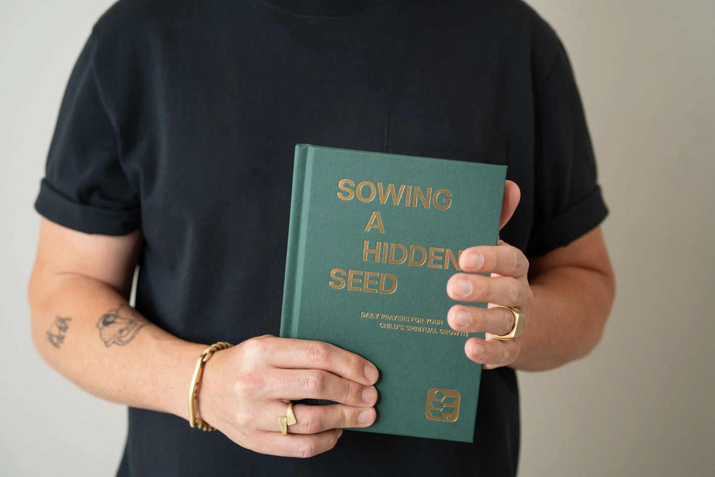 Sowing a Hidden Seed linen hardcover devotional held in hand