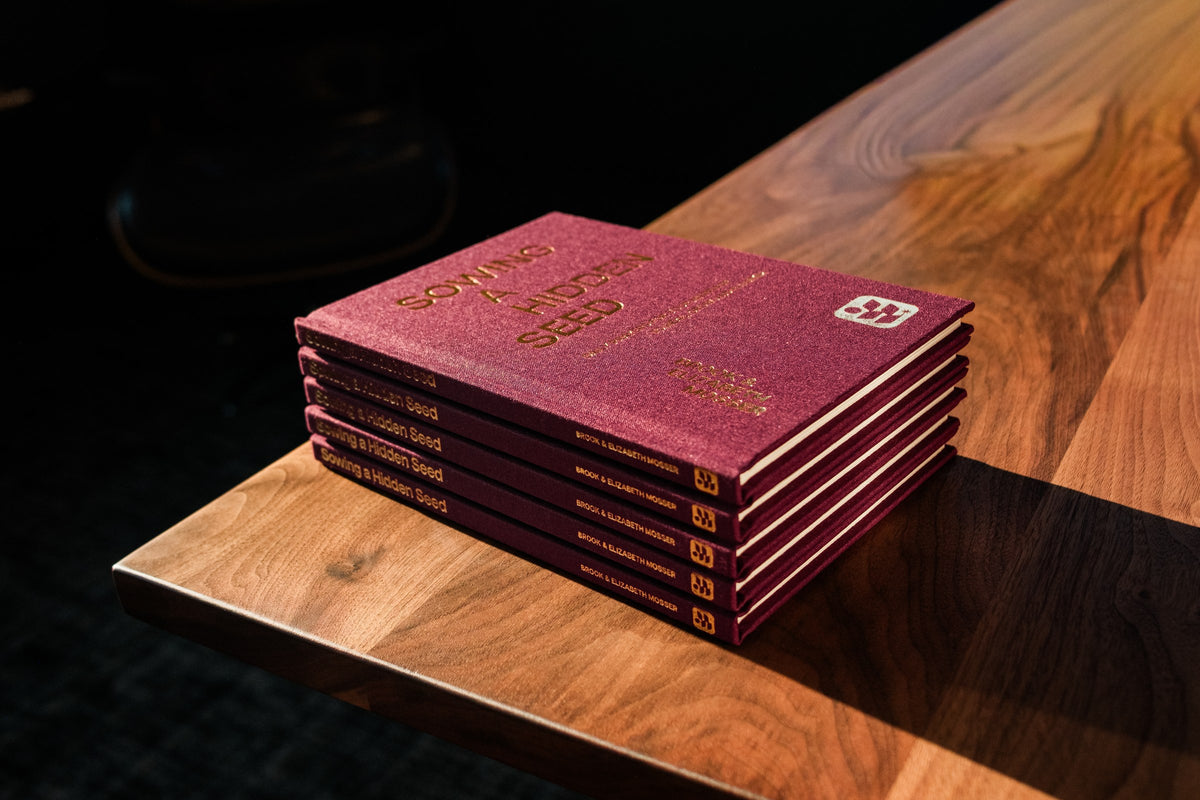 A stack of marriage devotionals on a wooden table